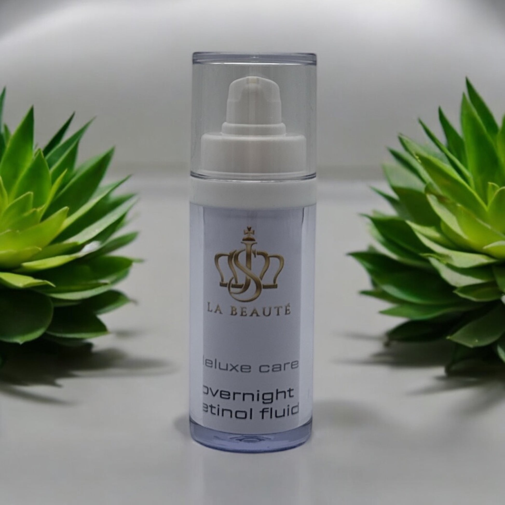 Flasche der JS La Beauté overnight retinol fluid aus der deluxe Care Serie mit Pumpspender – schlankes Design in Weiß und goldfarbenem Logo.