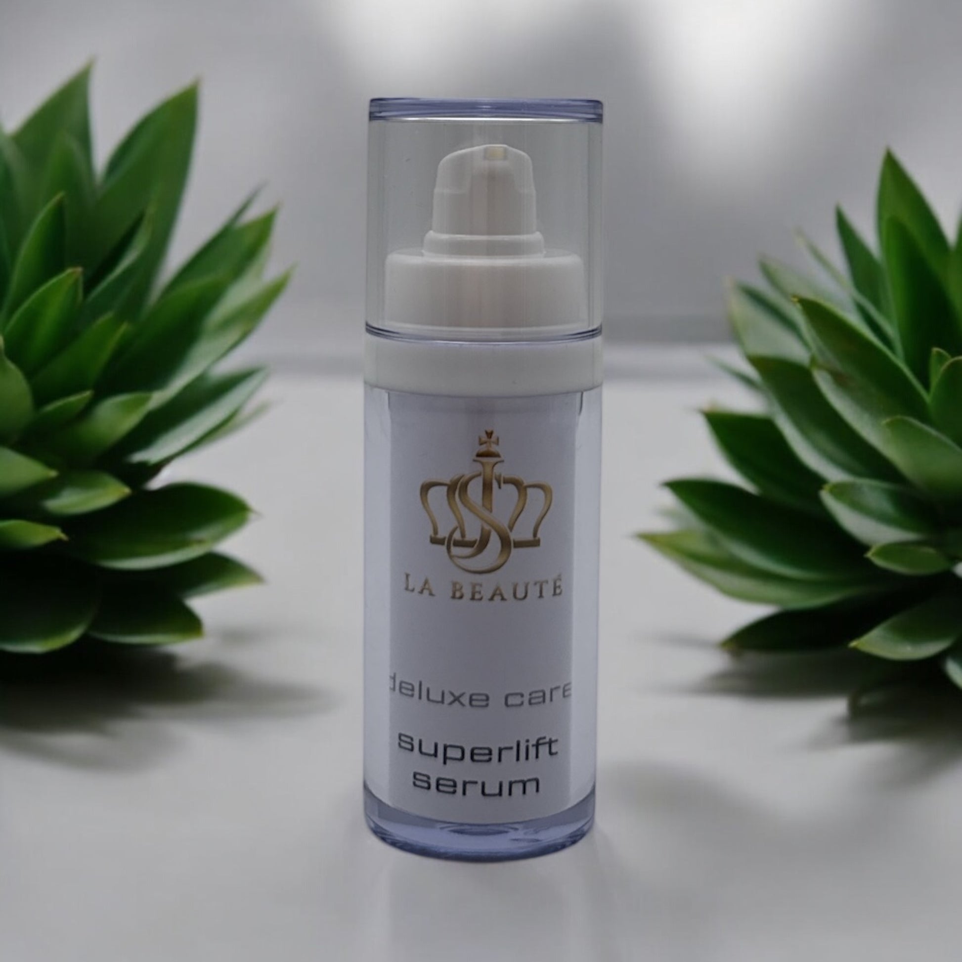 Flasche der JS La Beauté superlift serum aus der Med Care Serie mit Pumpspender – schlankes Design in Weiß und goldfarbenem Logo.