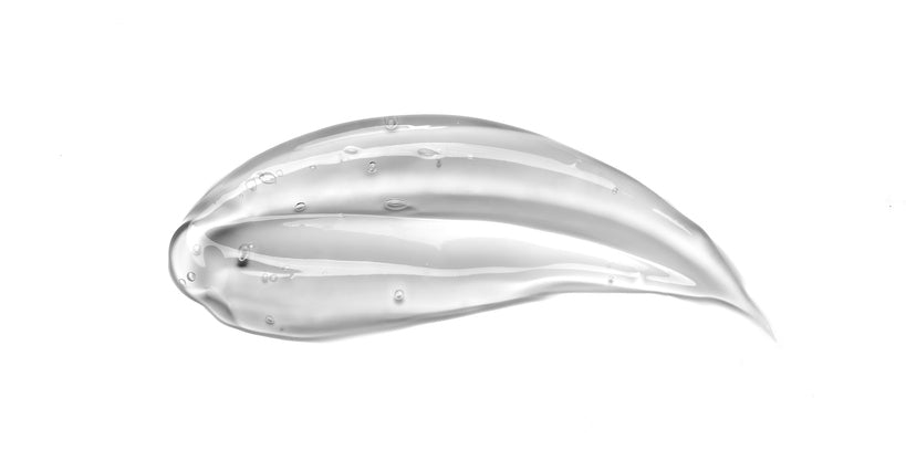 Flüssiges durchsichtiges Serum als verstrichener Tropfen mit einem weißen Hintergrund